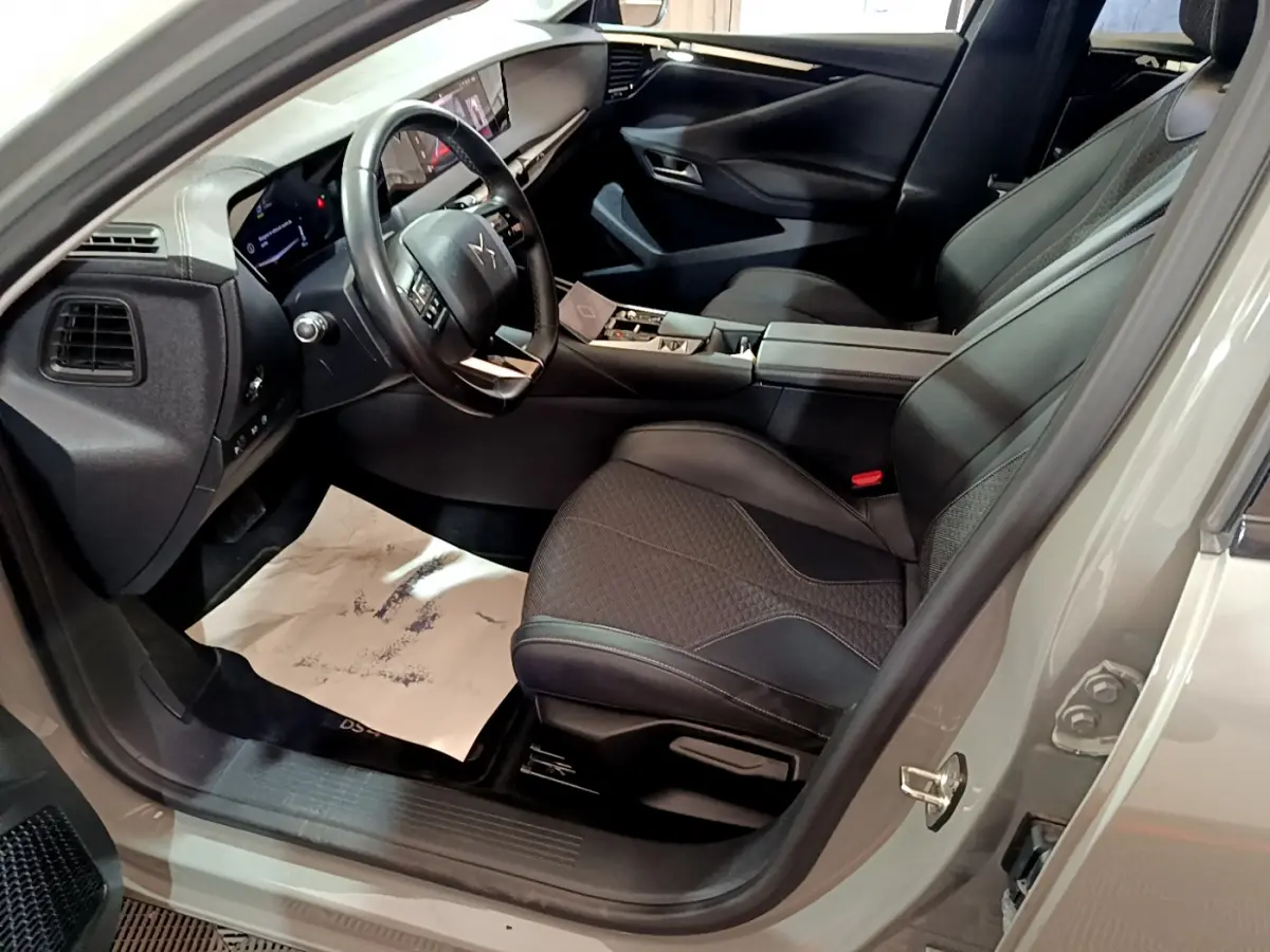 Intérieur côté conducteur du DS4 E-TENSE 225 TROCADERO gris foncé, volant cuir et sièges noirs élégants en vue rapprochée.