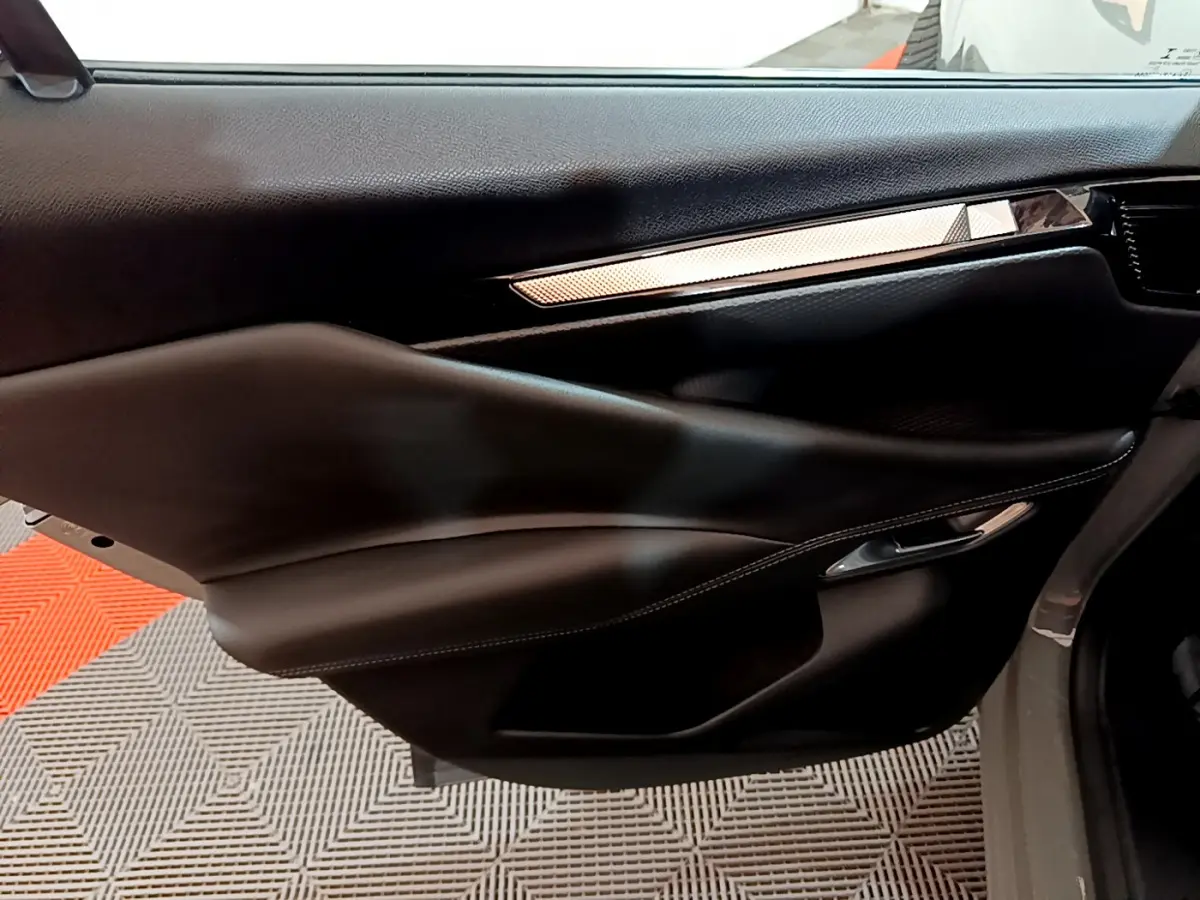 Gros plan sur la porte côté droit du DS4 E-TENSE 225 TROCADERO 2023 avec garniture noire et insert décoratif argenté.