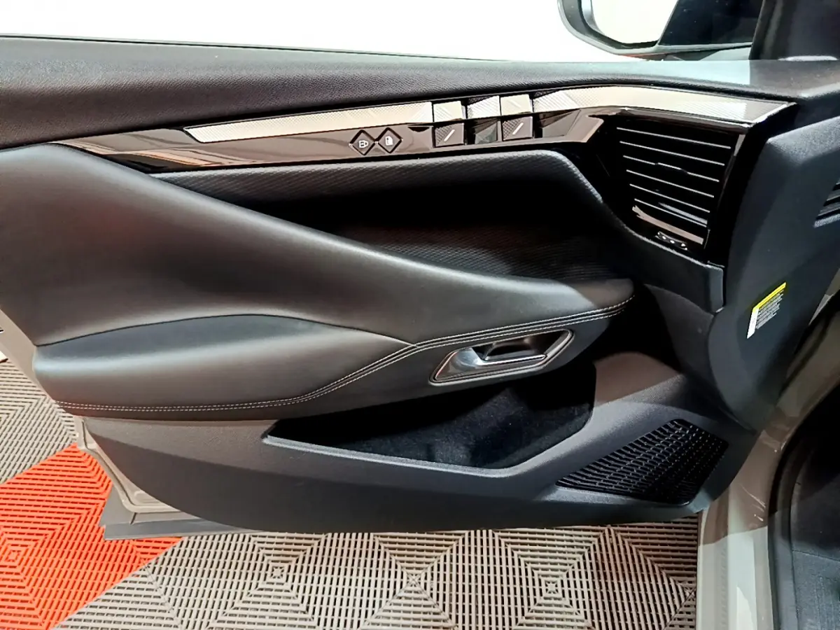 Vue rapprochée de la porte avant droite du DS4 E-TENSE 225 TROCADERO gris foncé, avec commandes de vitres et poignée intégrée.