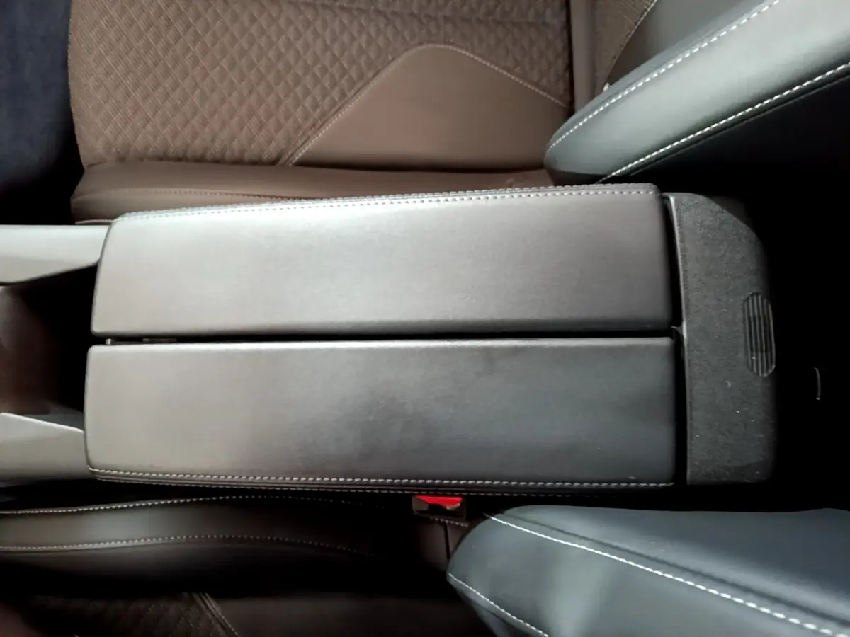 Vue plongeante sur l'accoudoir central noir et les sièges marron et noir du DS4 E-TENSE 225 TROCADERO 2023.