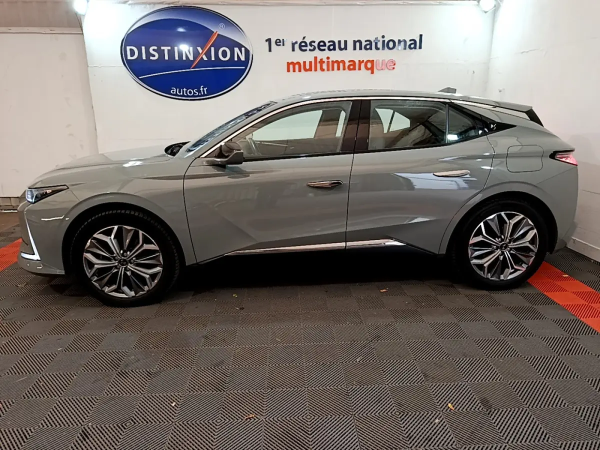 Profil côté gauche d'une DS4 E-TENSE 225 TROCADERO gris foncé 2023 avec jantes alliage et toit noir contrasté.