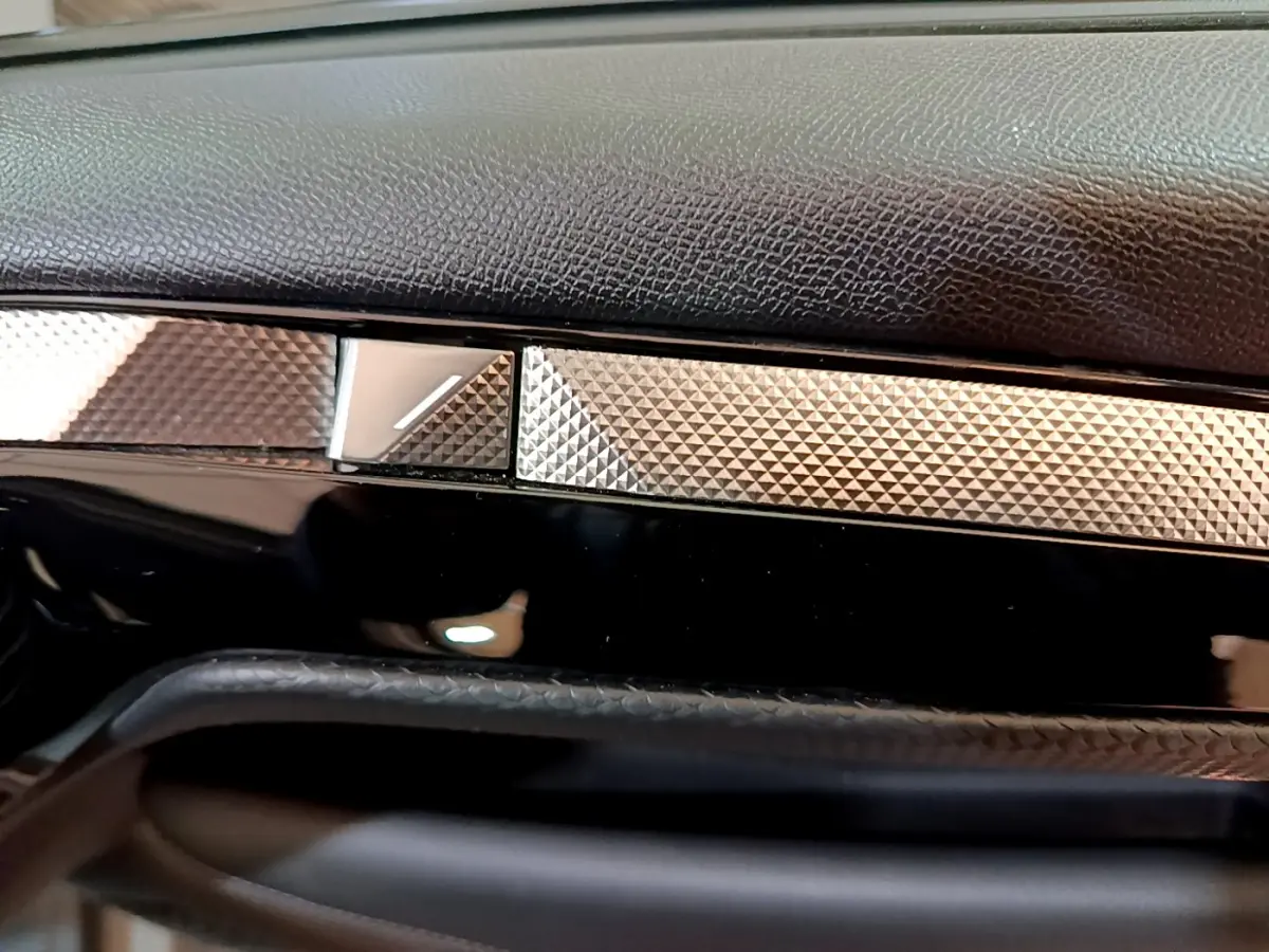 Détail du tableau de bord noir et argenté du DS4 E-TENSE 225 TROCADERO 2023, finition texturée élégante.