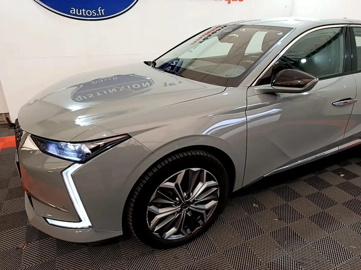 Vue 3/4 avant droit d'une DS4 E-TENSE 225 TROCADERO grise foncée avec phares LED et jantes alliage distinctives.