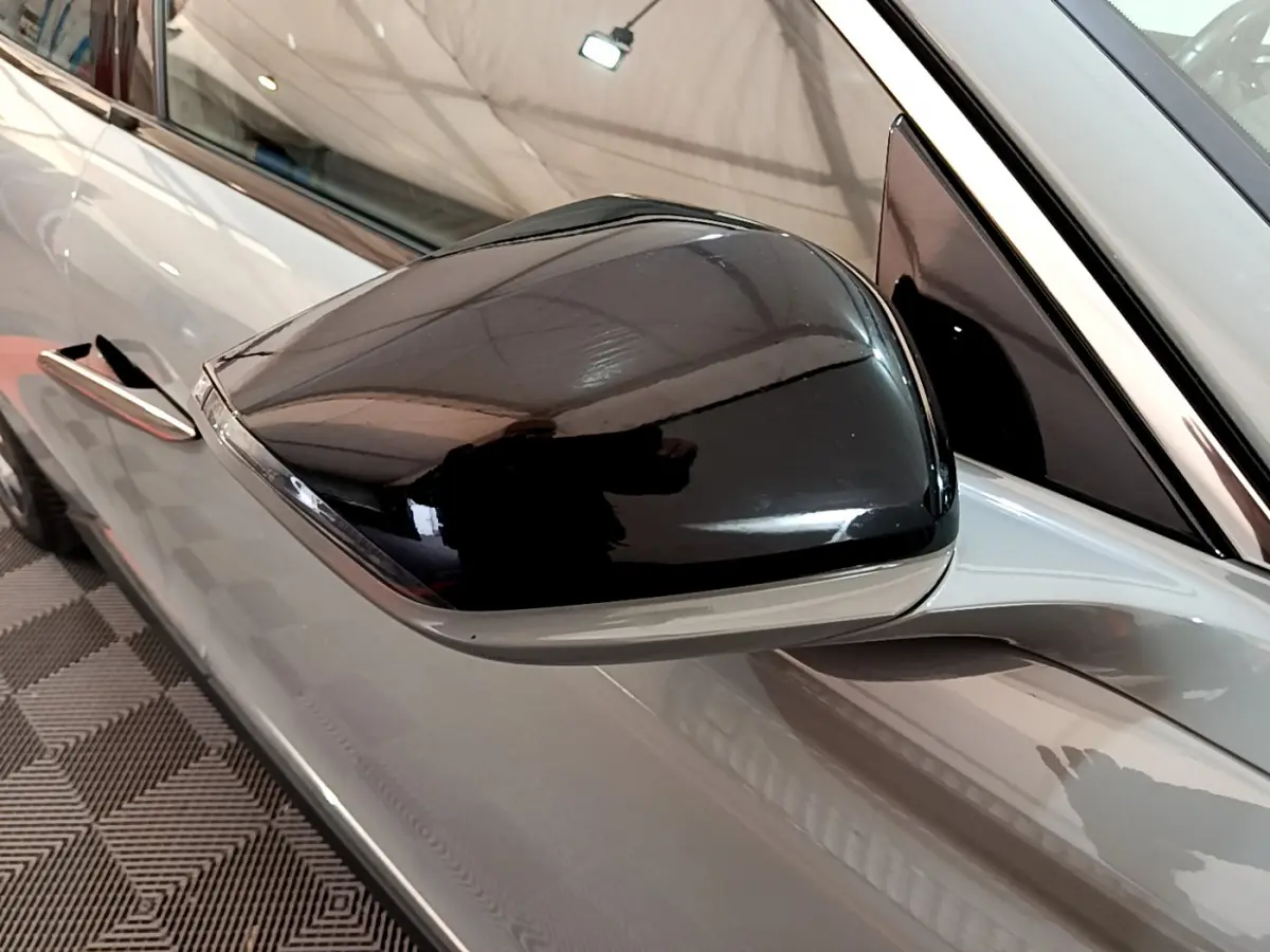 Gros plan sur le rétroviseur noir côté gauche du DS4 E-TENSE 225 TROCADERO gris foncé 2023.