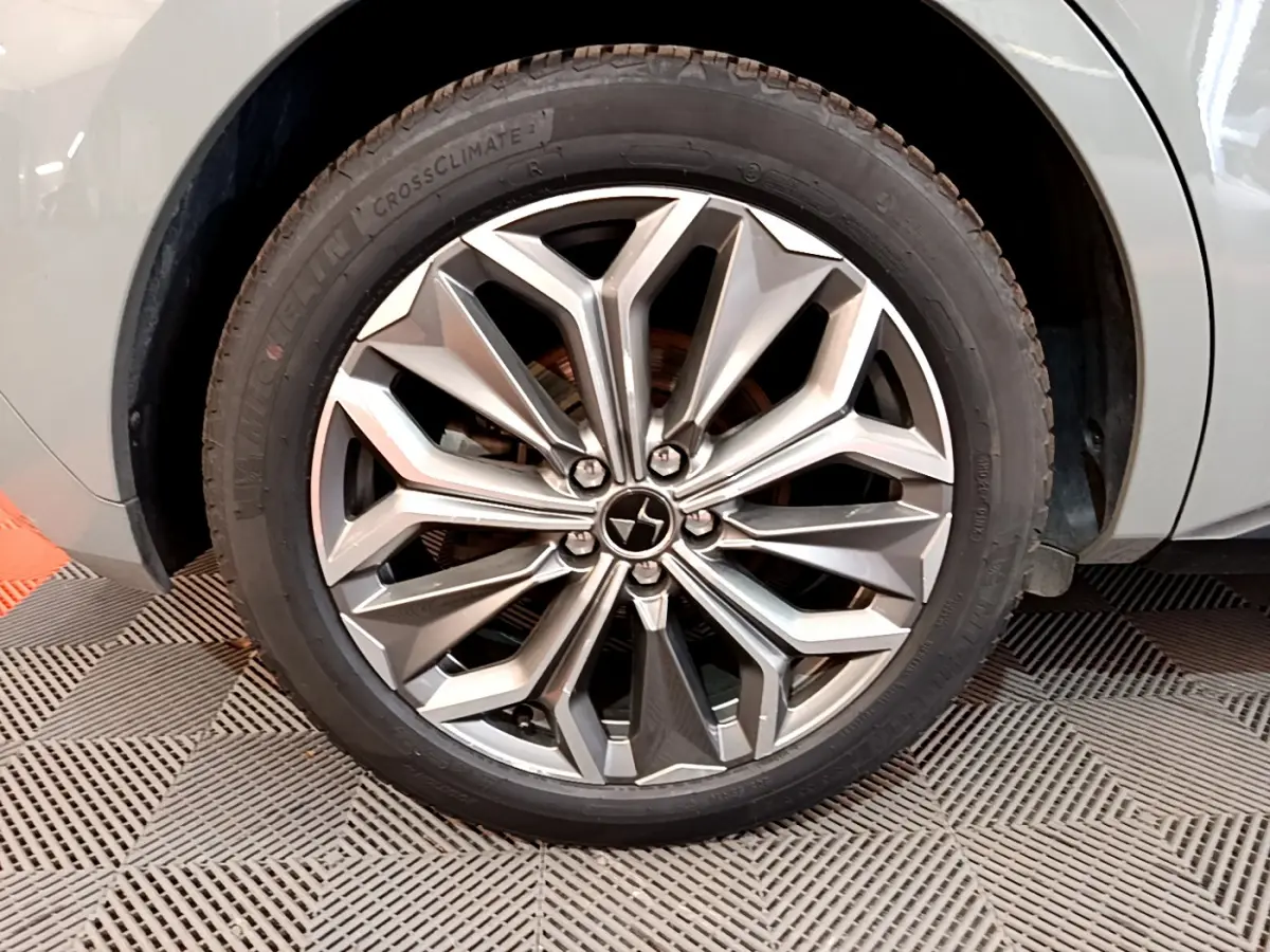 Gros plan sur la roue avant droite gris foncé du DS4 E-TENSE 225 TROCADERO avec jante alliage au design géométrique.