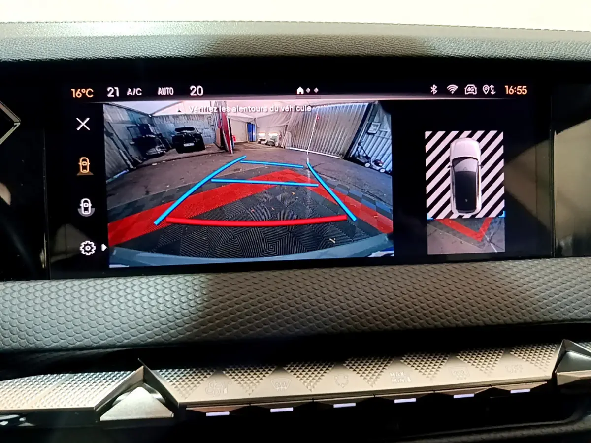 Écran tactile du tableau de bord montrant la caméra de recul et vue aérienne du DS4 gris foncé en stationnement.
