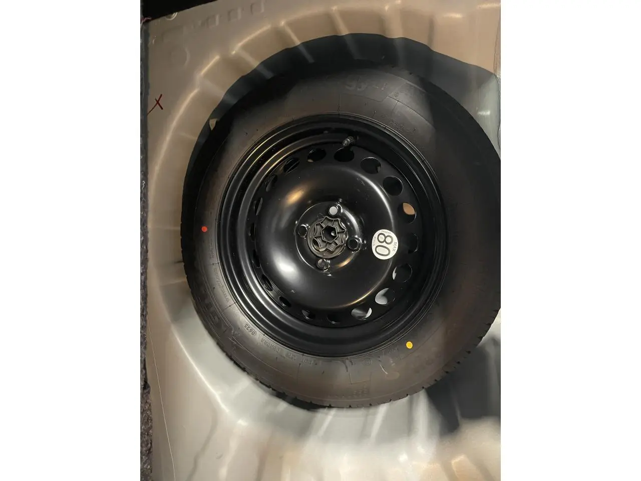 Gros plan sur la roue de secours noire du Dacia Sandero Stepway 2025, blanc glacier, avec étiquette de vitesse 80 km/h.