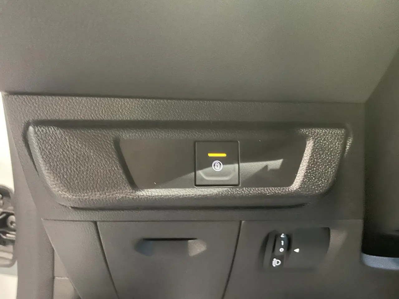 Dacia Sandero Stepway blanc glacier vue intérieure sur le bouton de frein à main électrique avec témoin lumineux allumé.