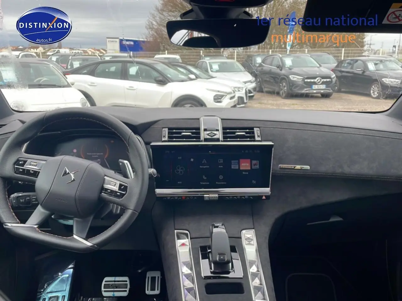 Vue intérieure frontale du tableau de bord du DS7 gris titane, avec écran tactile et volant cuir multifonctions.