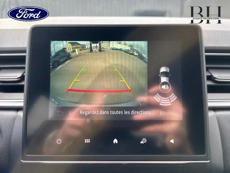 Écran tactile intérieur montrant la caméra de recul avec guidage coloré sur un Renault Captur gris Highland 2023.