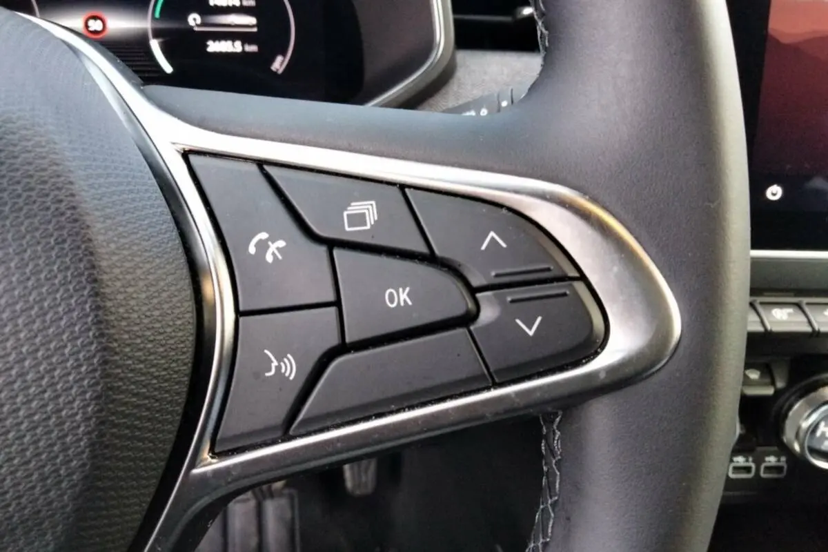 Gros plan sur les commandes multifonctions à droite du volant cuir noir de la Renault Clio Gris Rafale 2025.