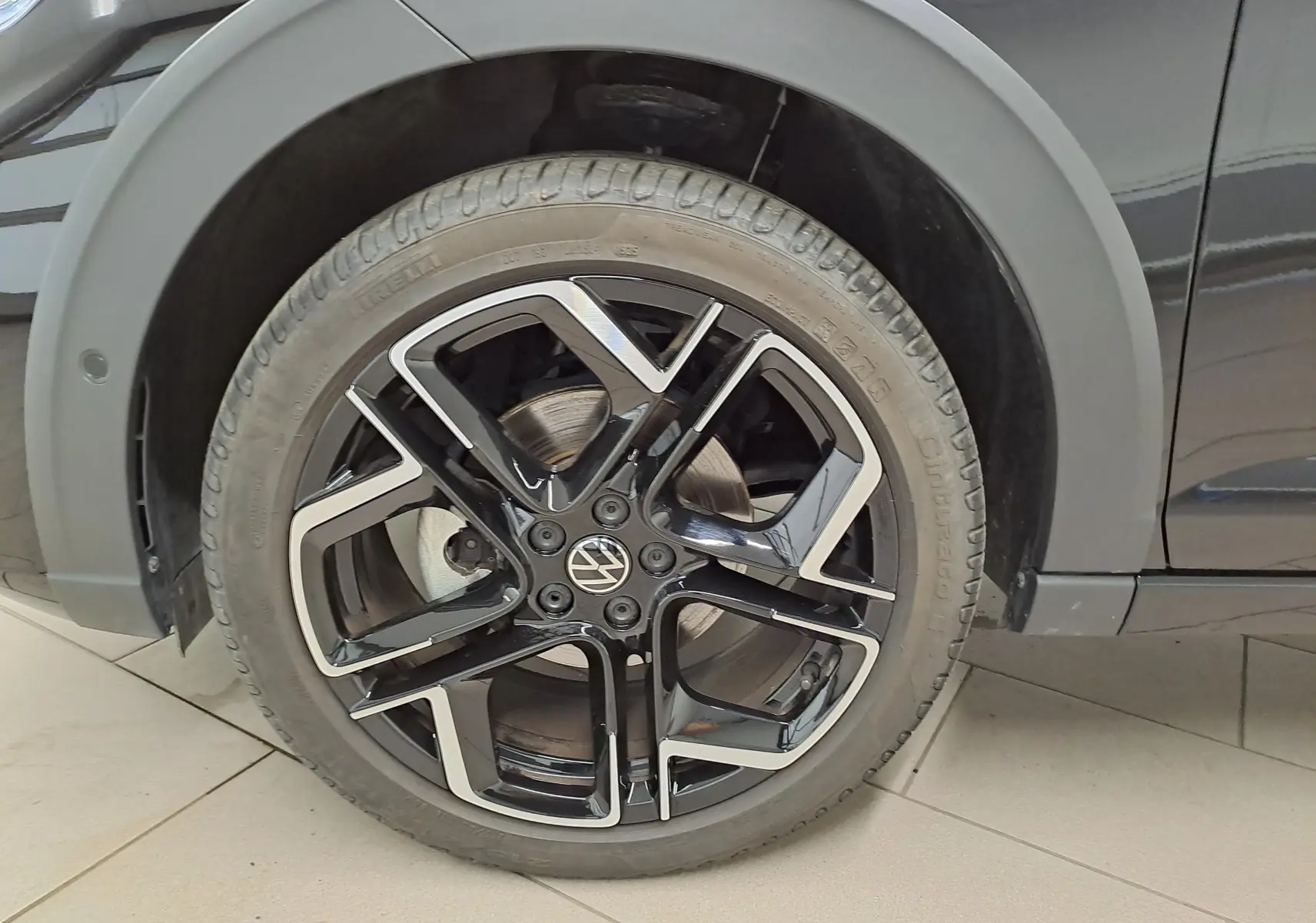 Gros plan sur la roue avant droite avec jante alliage noir et argent du Volkswagen Taigo Noir Intense nacré.
