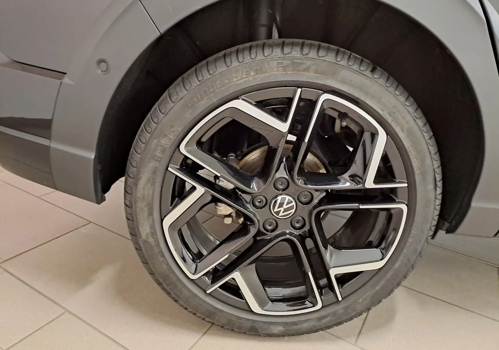 Gros plan sur la jante alliage noir et argentée du côté arrière droit du Volkswagen Taigo noir intense nacré.
