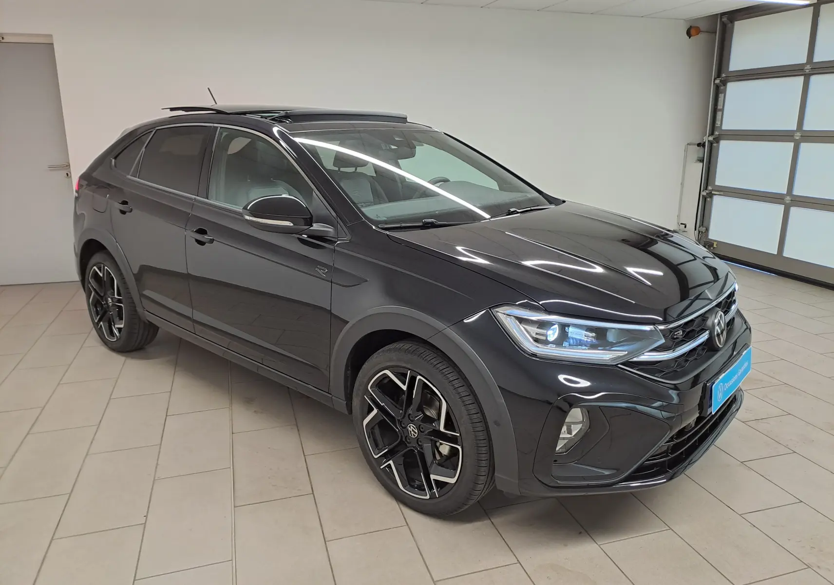 Volkswagen Taigo 1.5 TSI R-Line noir nacré, vue 3/4 avant droit avec jantes alliage et toit ouvrant électrique.