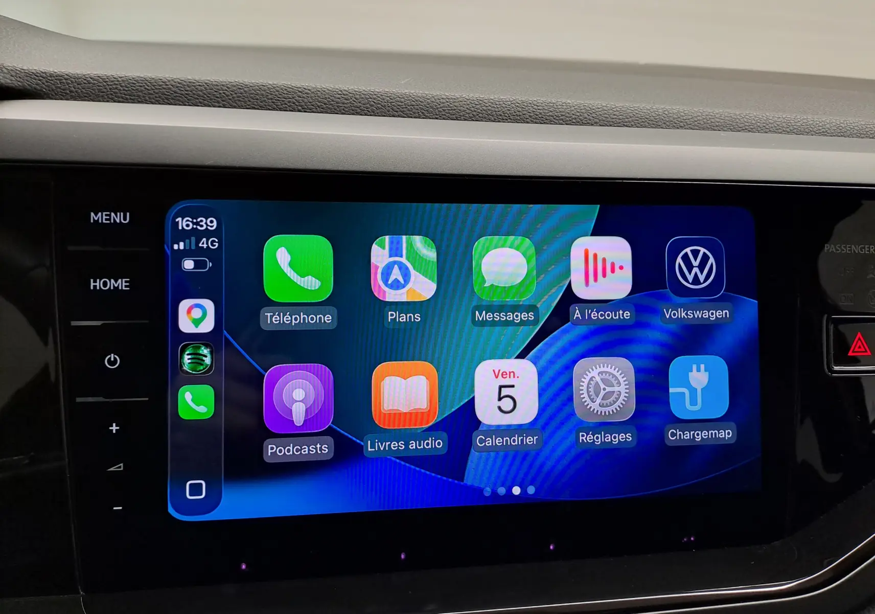 Écran tactile central du Volkswagen Taigo 2025 affichant Apple CarPlay avec icônes colorées, intérieur noir.