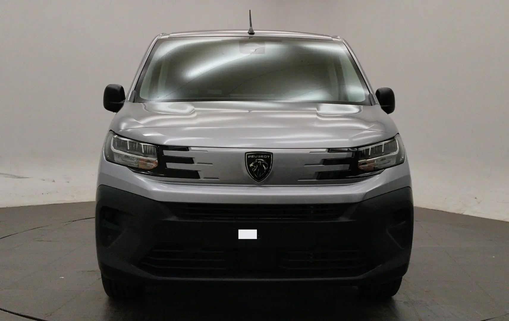 Vue frontale d’un Peugeot Partner Fourgon gris acier avec calandre noire et pare-chocs noir mat.