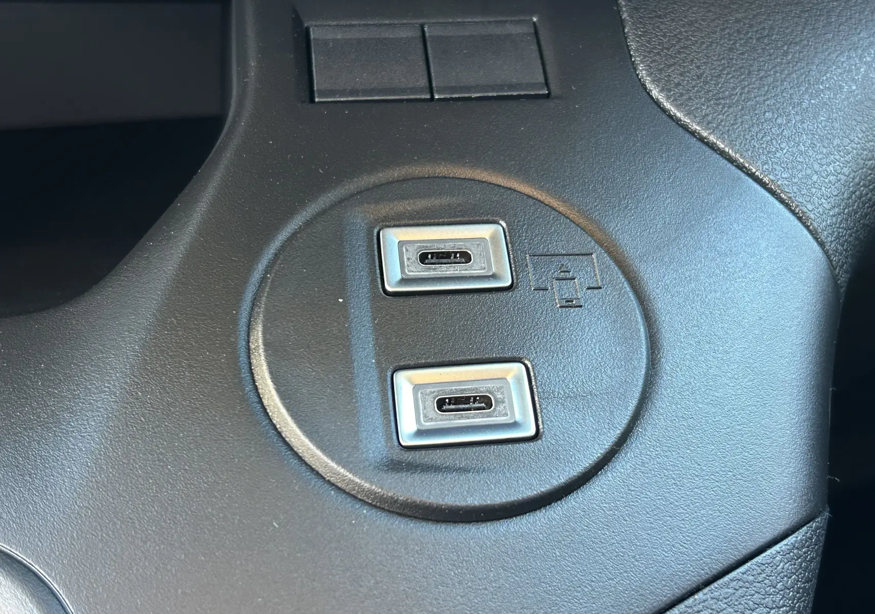 Gros plan sur deux ports USB-C intégrés dans la console centrale noire du Peugeot Partner Fourgon gris acier.