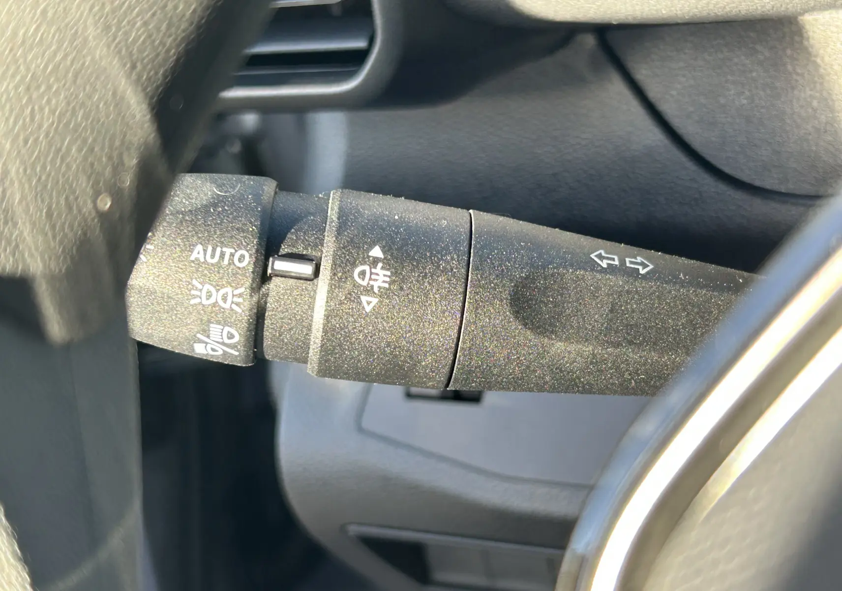 Gros plan sur la manette de commande des phares et clignotants à gauche du volant du Peugeot Partner Fourgon gris acier.