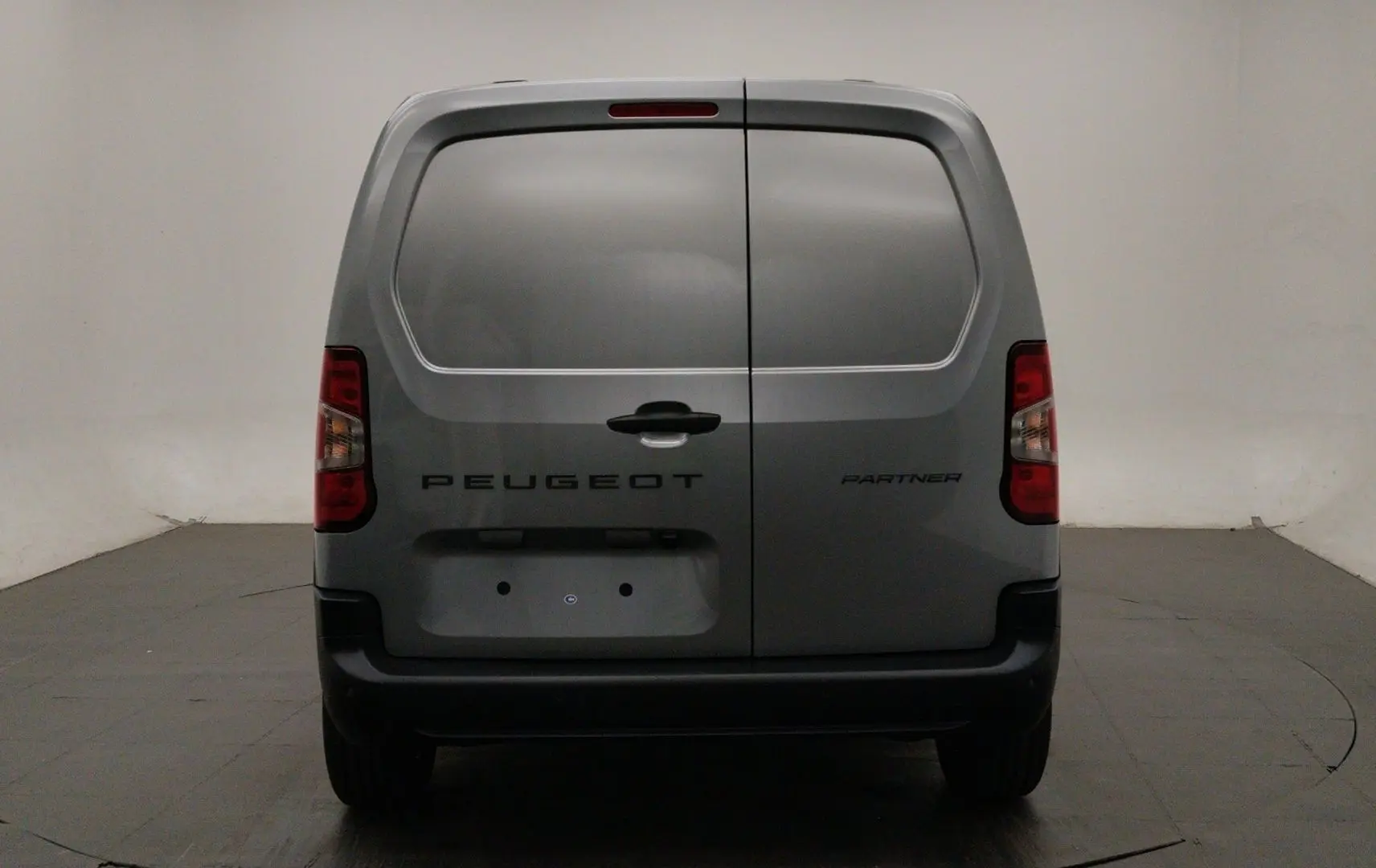Vue arrière du Peugeot Partner Fourgon gris acier 2026 avec portes battantes et feux arrière verticaux.