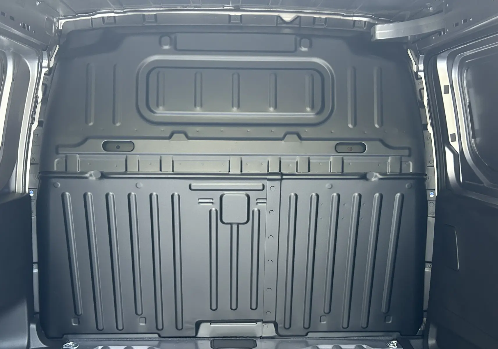 Vue intérieure arrière du fourgon Peugeot Partner III Ph.2 gris acier, montrant la cloison métallique de séparation du coffre.