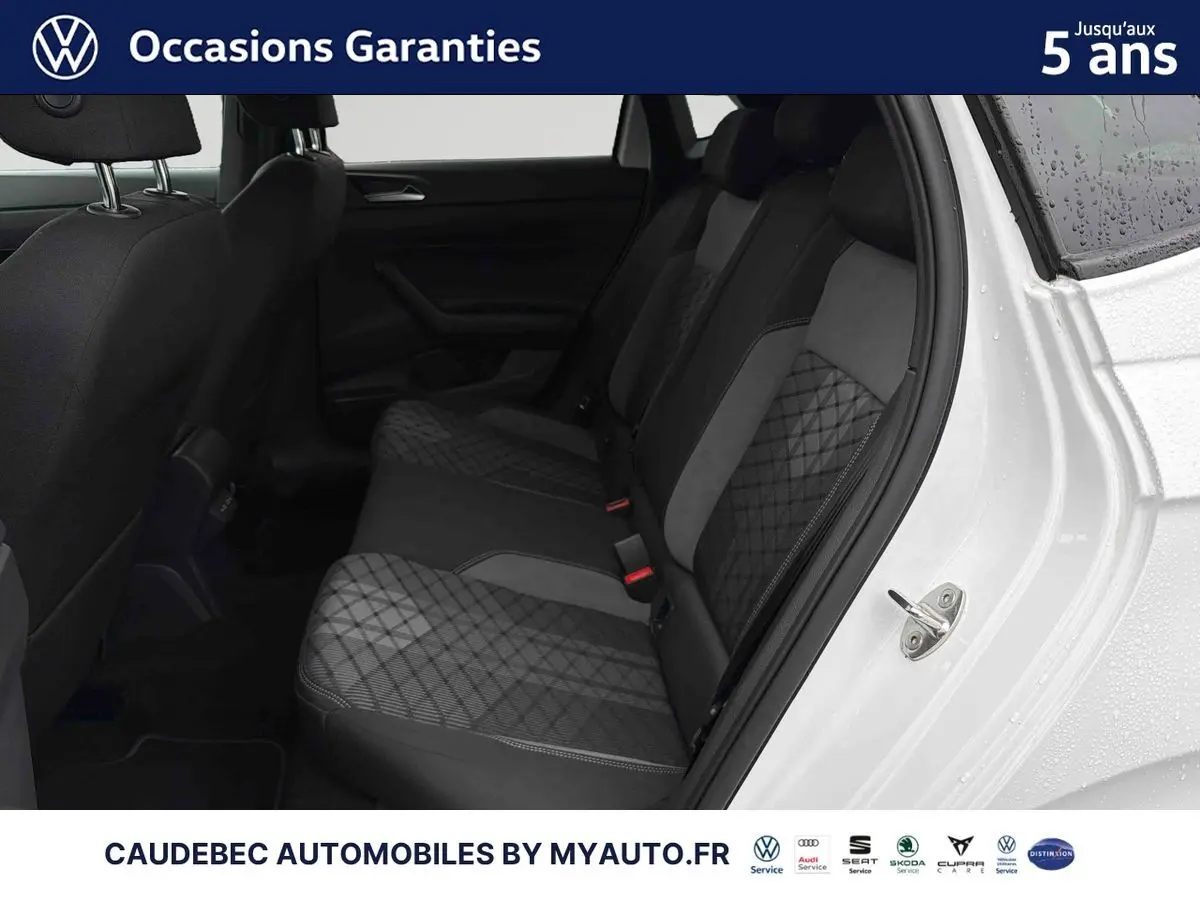 Vue intérieure côté arrière droit de la Volkswagen Polo blanche 2025, montrant les sièges arrière en tissu gris à motifs géométriques.