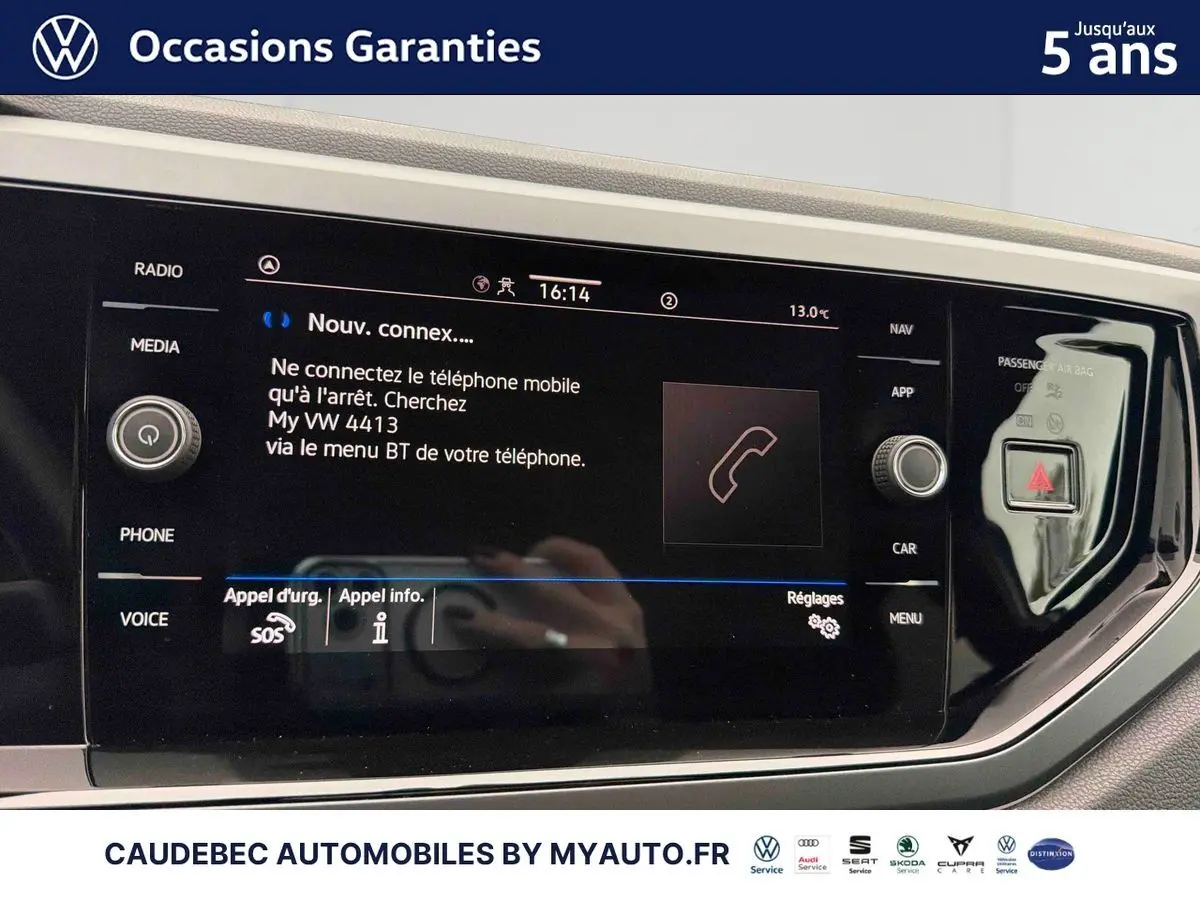Écran tactile central de la Volkswagen Polo blanche 2025 affichant la connexion Bluetooth et commandes multimédia.