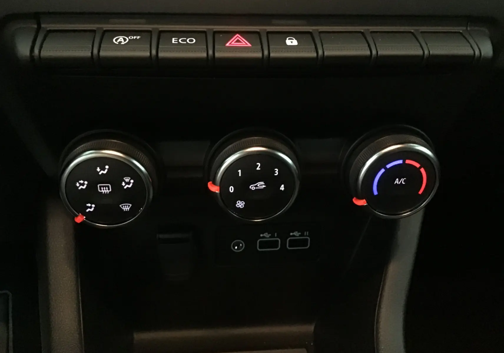 Commandes de climatisation manuelle et boutons de fonction sur tableau de bord noir de Renault Clio V 2025.