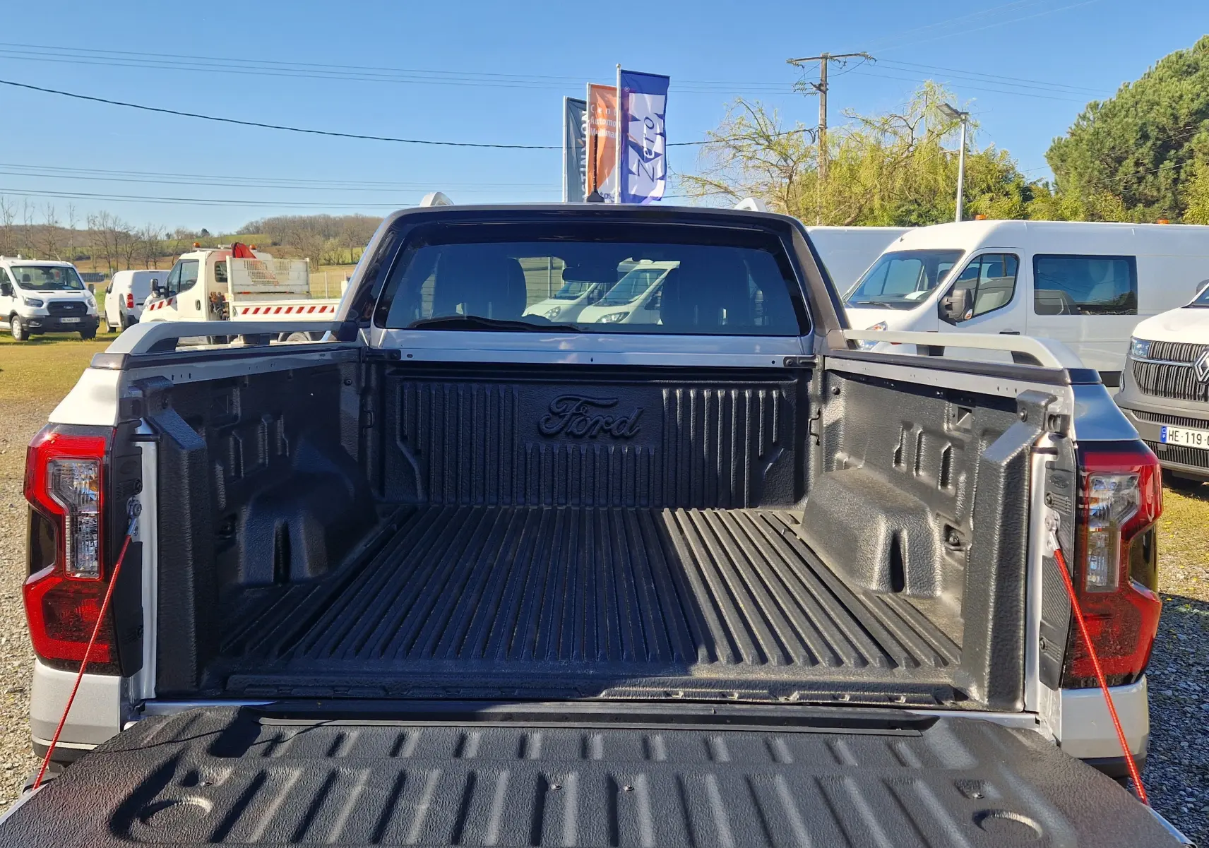 Vue arrière du Ford Ranger Super Cabine gris Iconic avec benne ouverte et revêtement noir marqué Ford.
