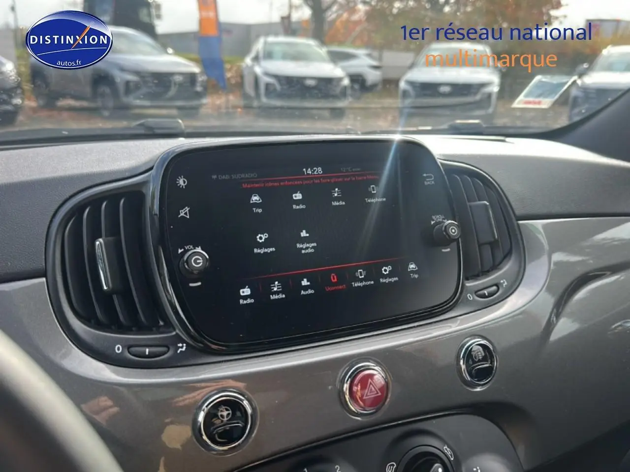 Vue intérieure centrée sur l'écran tactile et la console grise d'une Fiat 500 1.0 70 bsg cult de 2022.