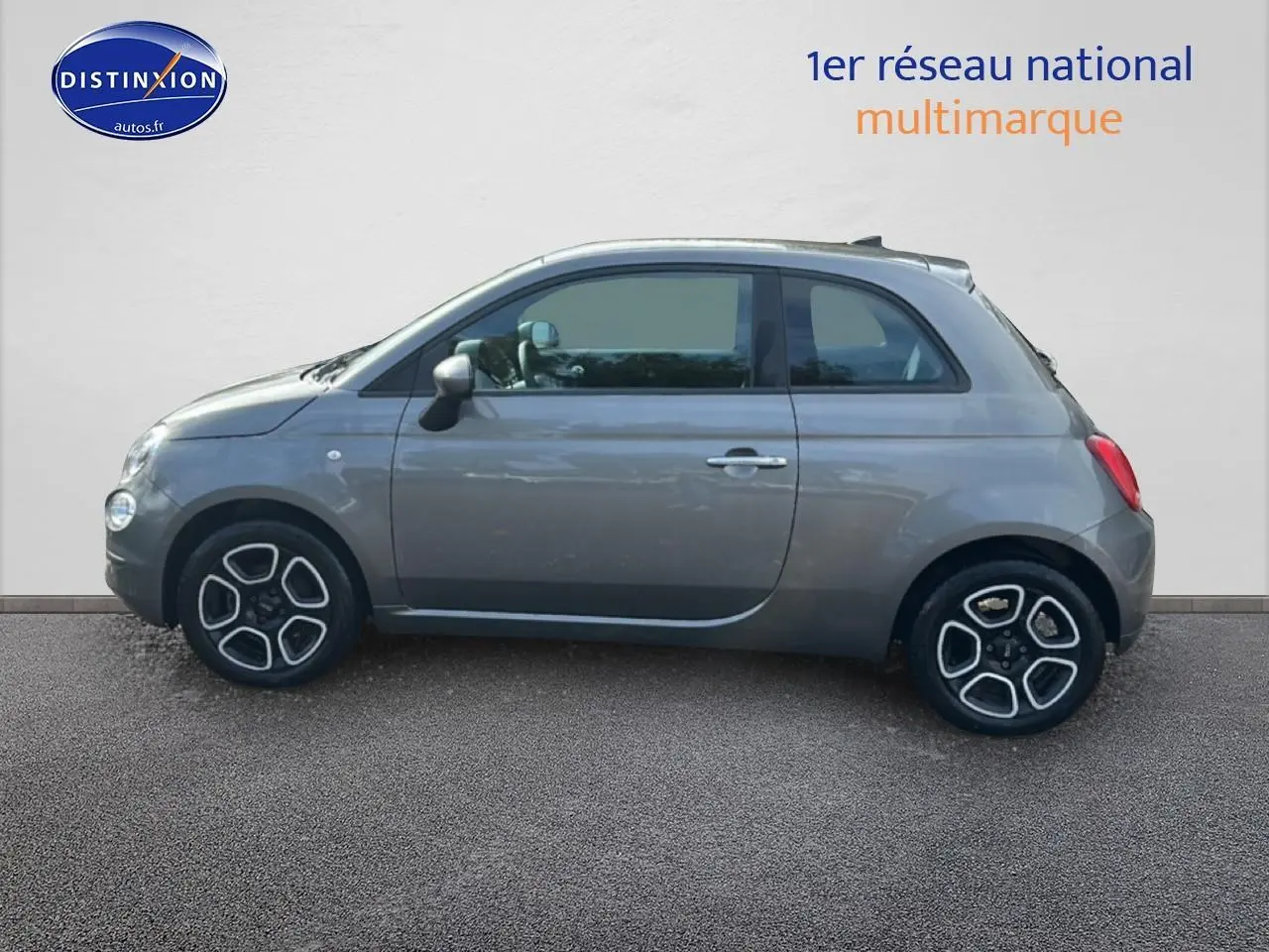 Profil côté gauche d'une Fiat 500 gris 2022 avec jantes noires et détails argentés sur fond neutre.