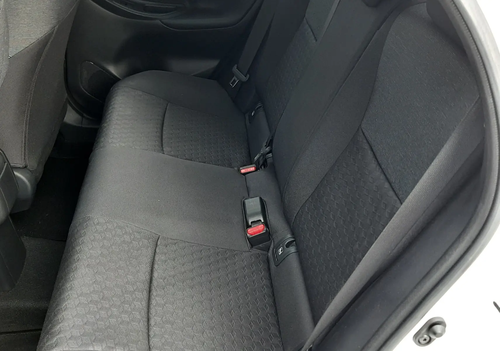 Vue intérieure côté droit des sièges arrière en tissu noir de la Toyota Yaris 1.5 Hybrid blanche 2023.