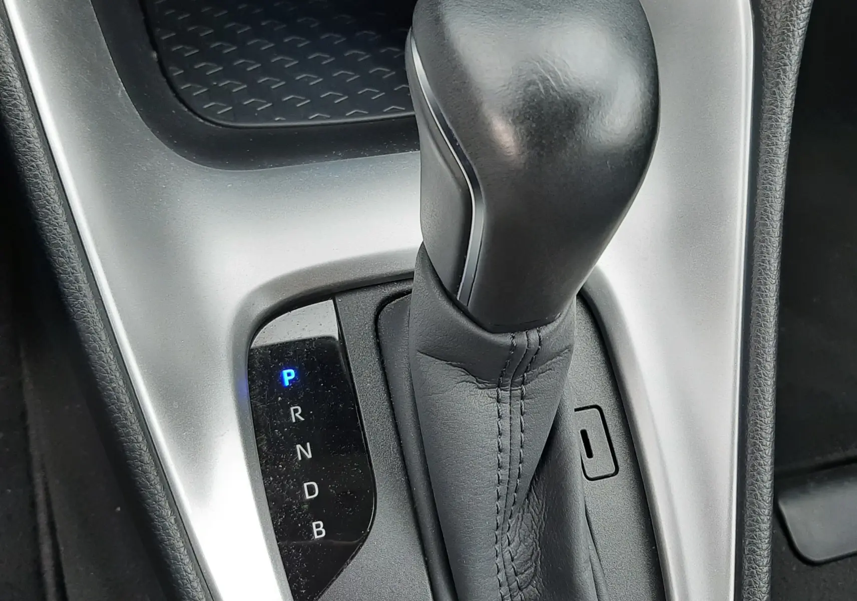 Gros plan sur le levier de vitesses automatique noir de la Toyota Yaris 1.5 Hybrid 2023, avec indication lumineuse de la position P.