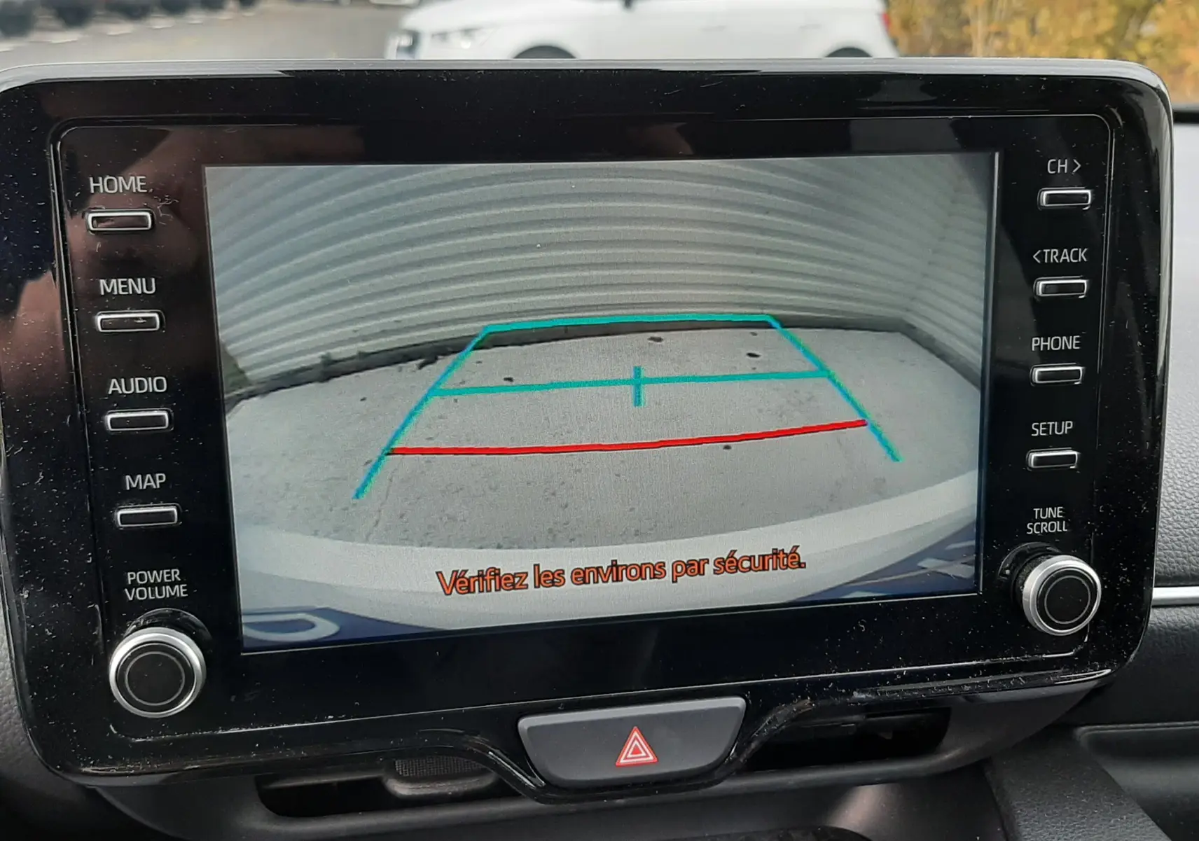 Écran central de la Toyota Yaris 1.5 Hybrid 2023 montrant la caméra de recul avec lignes de guidage colorées.