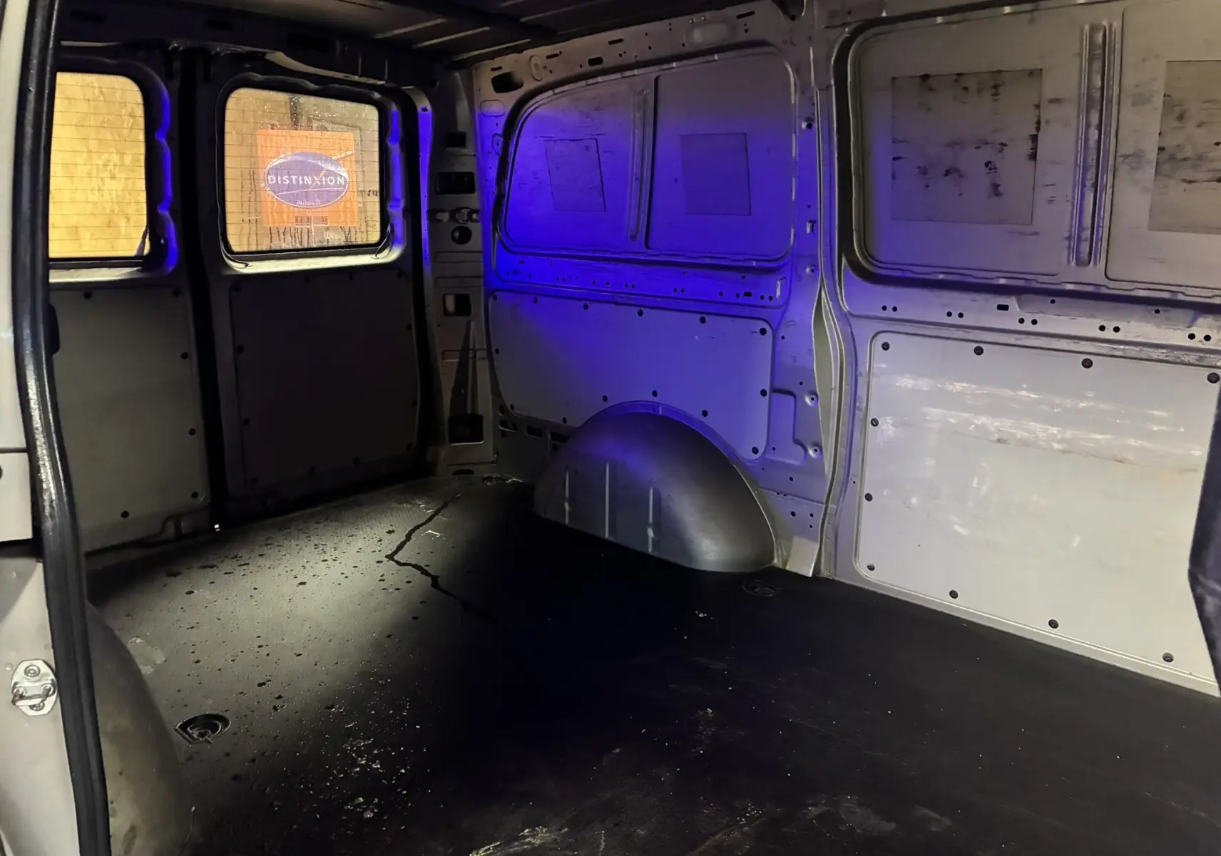 Vue intérieure arrière du fourgon long Mercedes Vito gris 2012, montrant l’espace de chargement vide avec parois métalliques.