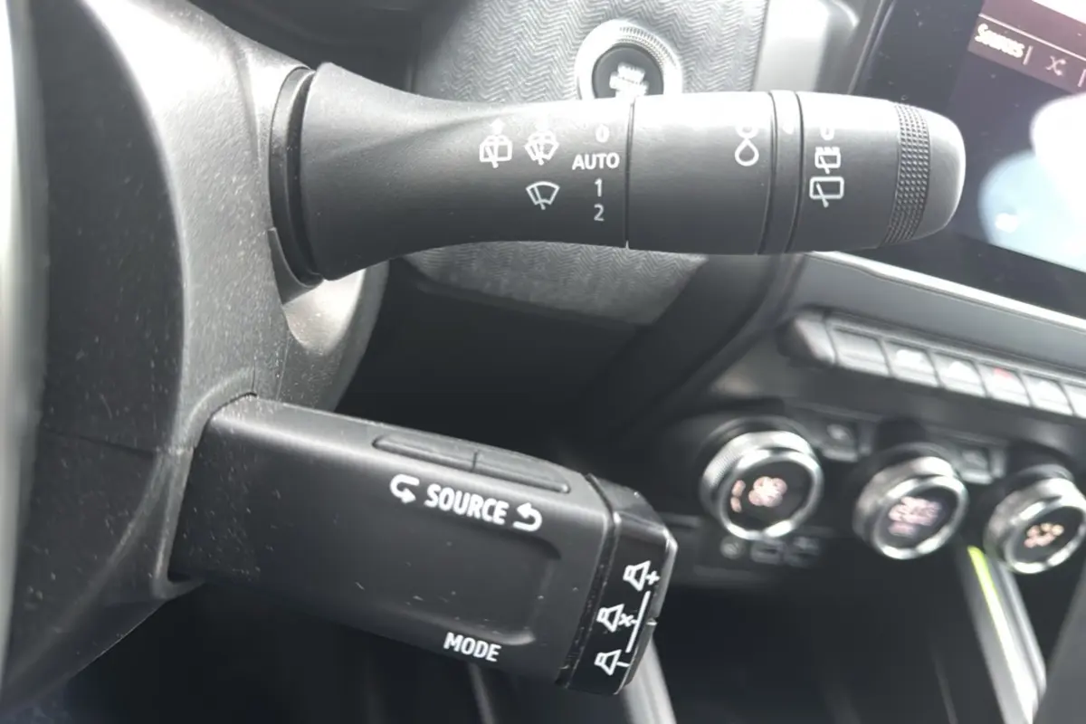 Détail du commodo multifonctions et commandes de climatisation dans l’habitacle de la Renault Clio V TCe 90 Techno Plus.