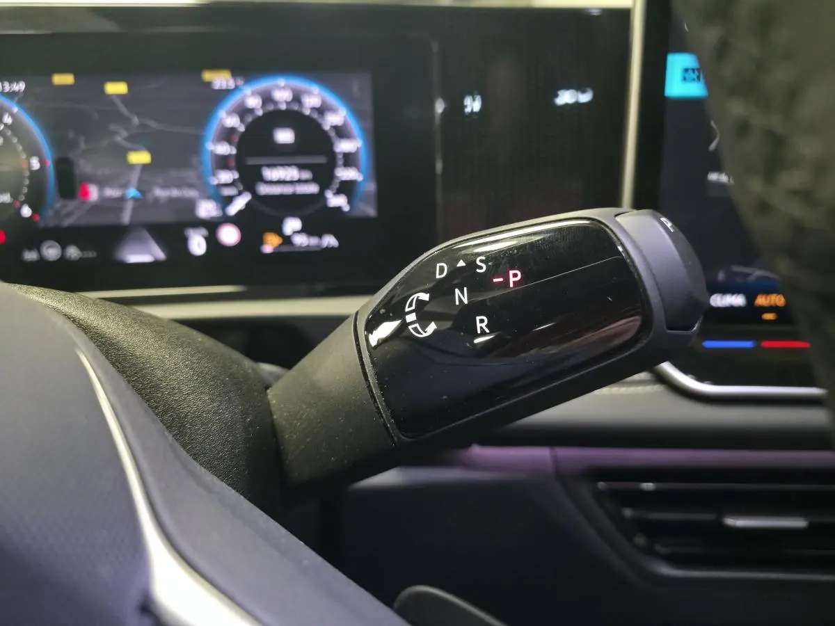 Gros plan sur la commande de boîte automatique noire du Volkswagen Tiguan 2025, avec tableau de bord numérique en arrière-plan.