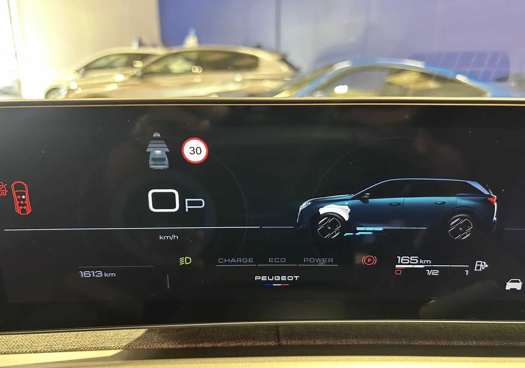 Affichage numérique du tableau de bord montrant la silhouette bleue du Peugeot 5008 Hybrid côté droit et les informations de conduite.