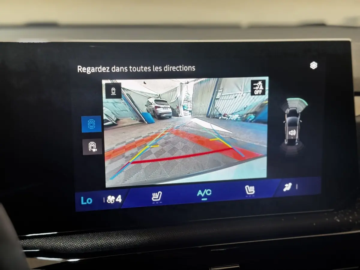 Écran tactile intérieur montrant la caméra de recul et l'aide au stationnement de la Renault Clio gris clair.
