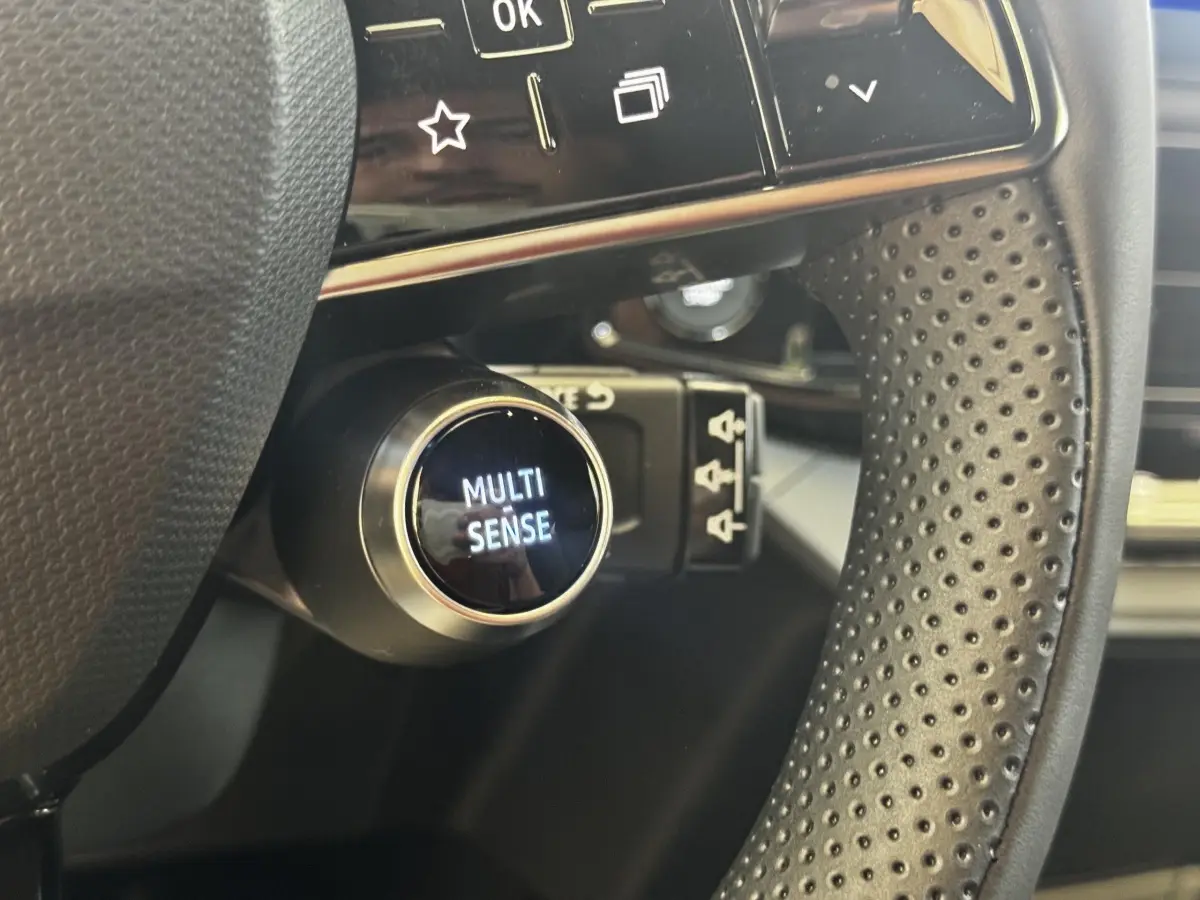 Gros plan sur le bouton Multi-Sense derrière le volant perforé du Renault Clio Techno TCe 115 essence 2026.
