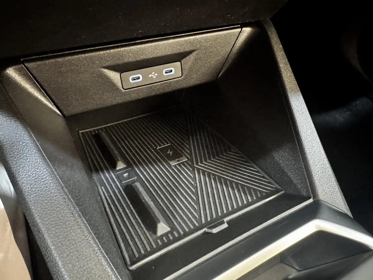 Gros plan sur la console centrale de la Renault Clio gris clair 2026, montrant le chargeur sans fil et ports USB-C.