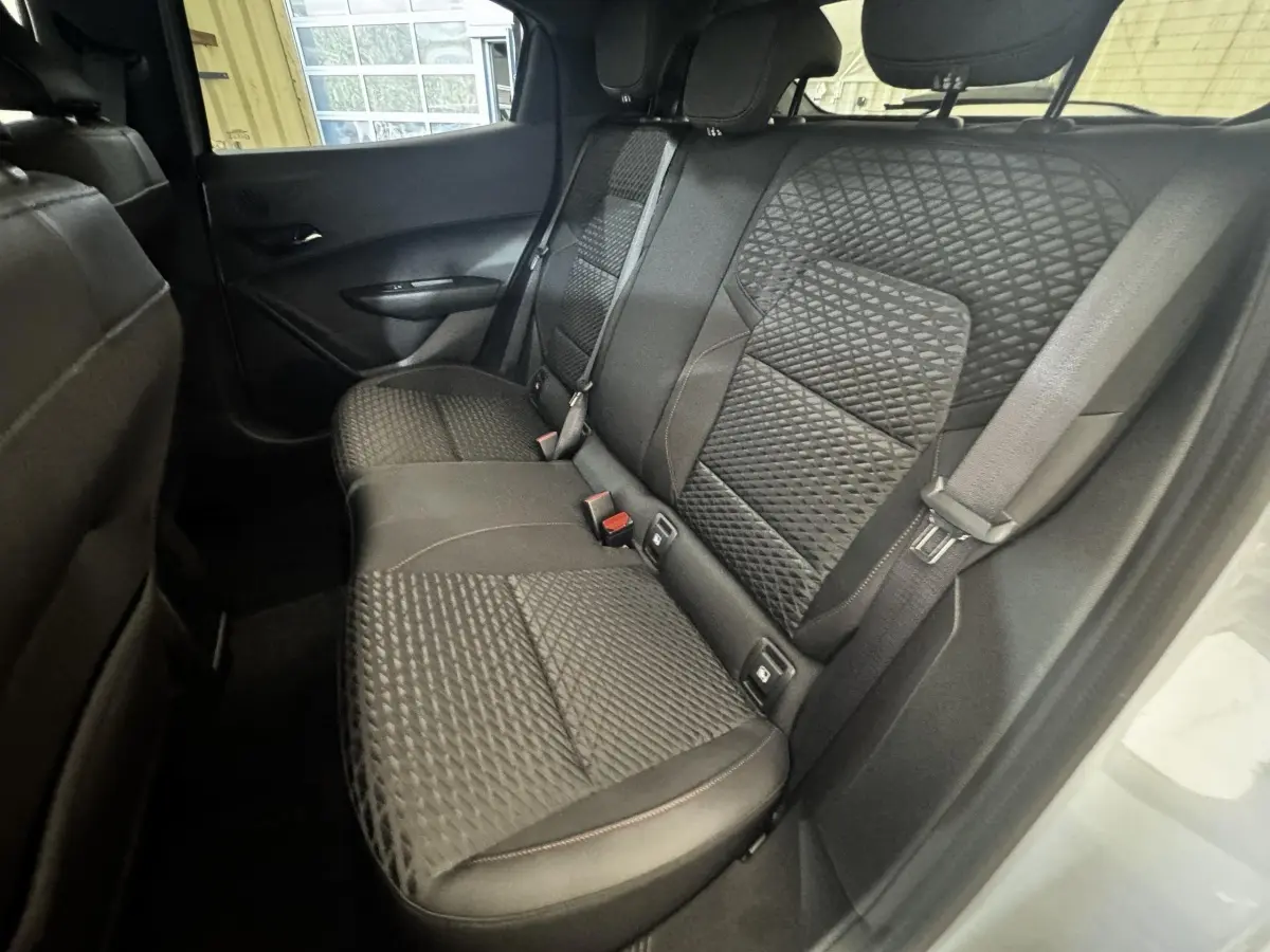 Vue intérieure arrière côté droit de la Renault Clio 2026, sièges tissu noir avec motifs géométriques.
