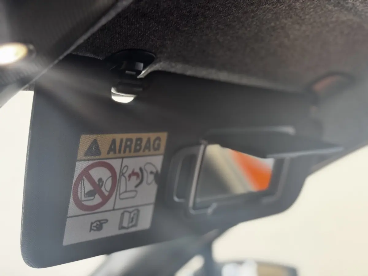 Détail du pare-soleil côté conducteur avec miroir et avertissement airbag dans Renault Clio gris clair 2026.