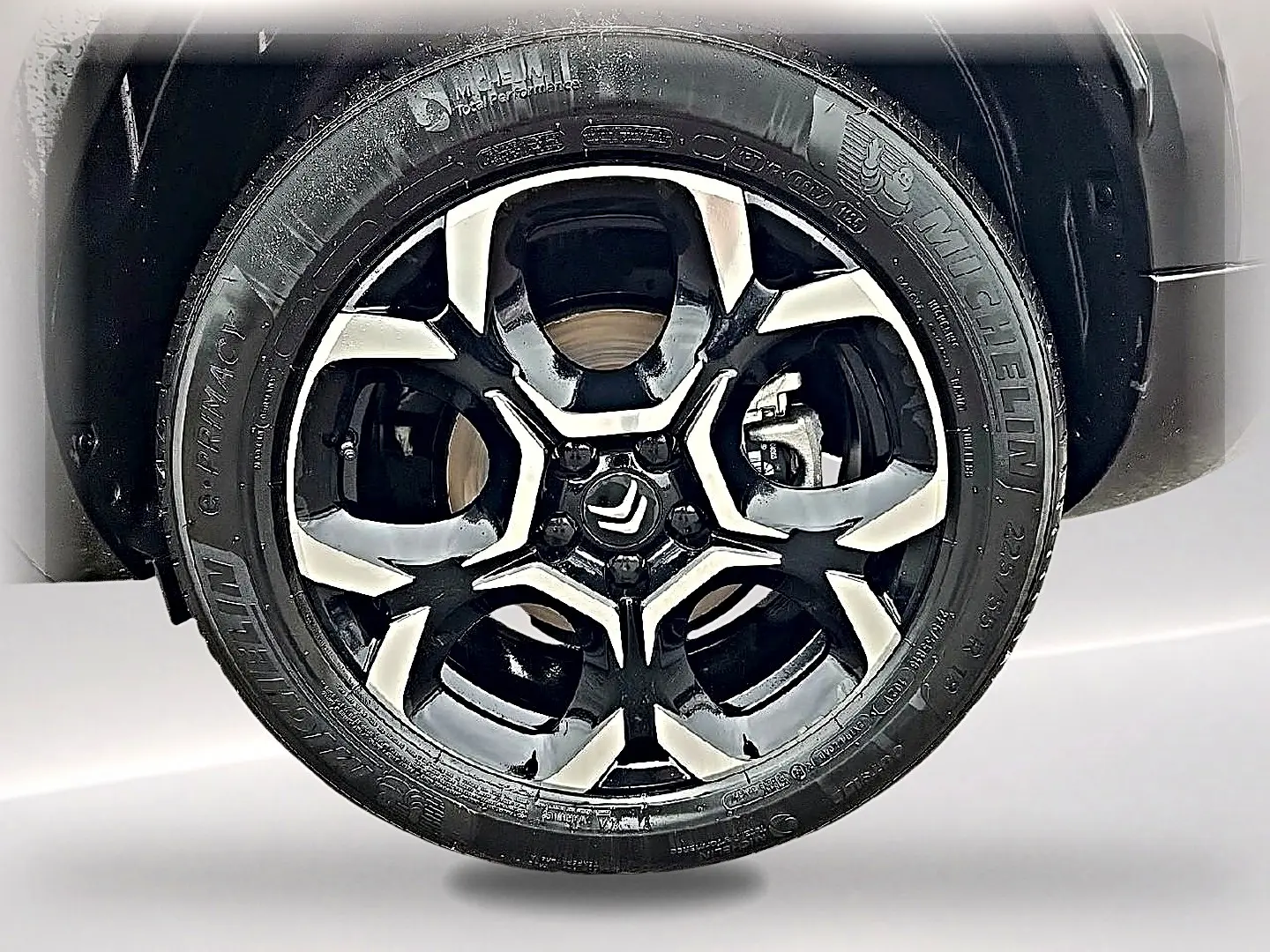 Gros plan sur la jante alu bicolore noire et argentée du Citroën C5 Aircross gris, avec logo Citroën au centre.