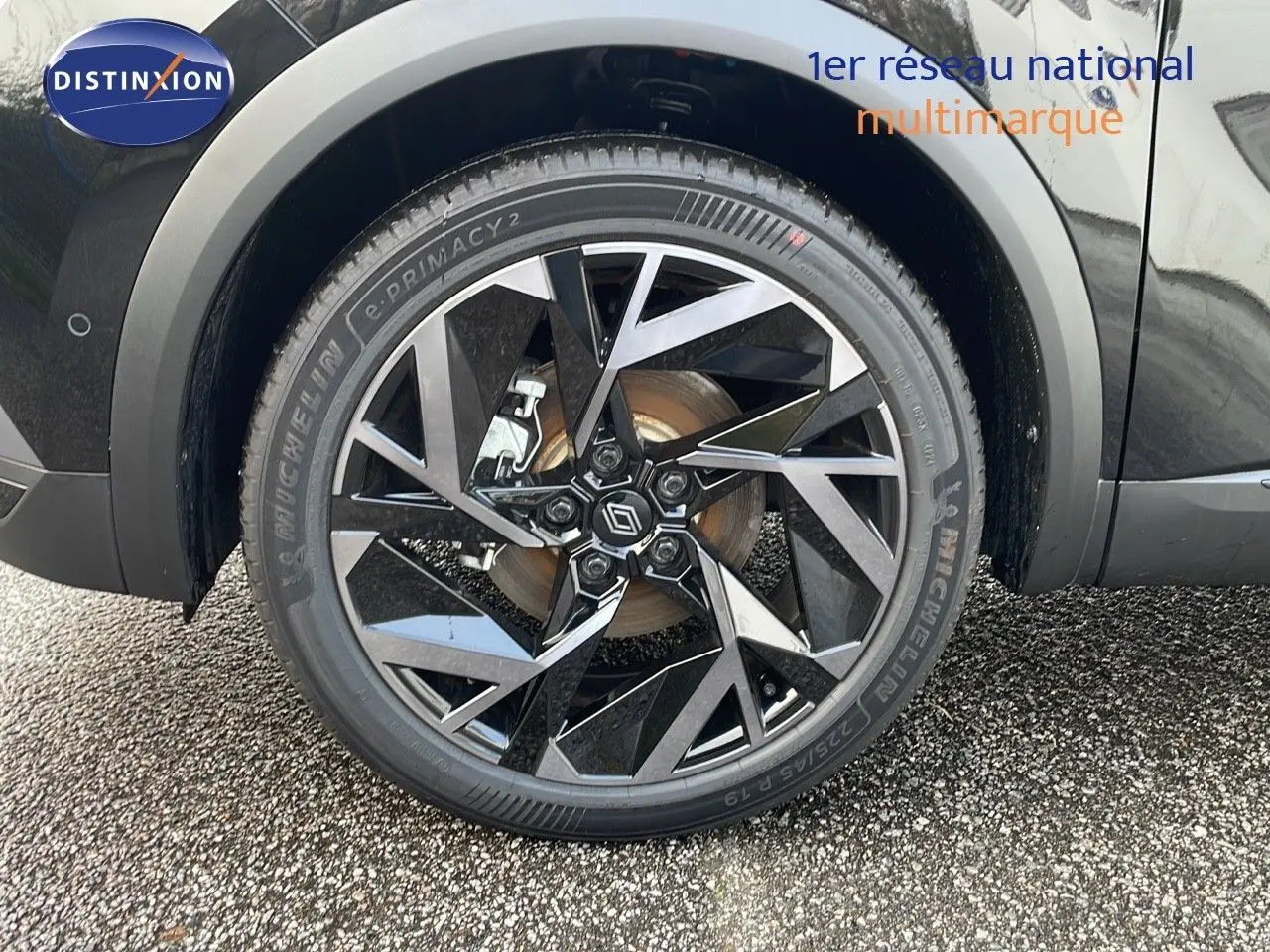 Gros plan sur la roue avant droite du Renault Captur noir étoile avec jante alu bicolore au design géométrique.