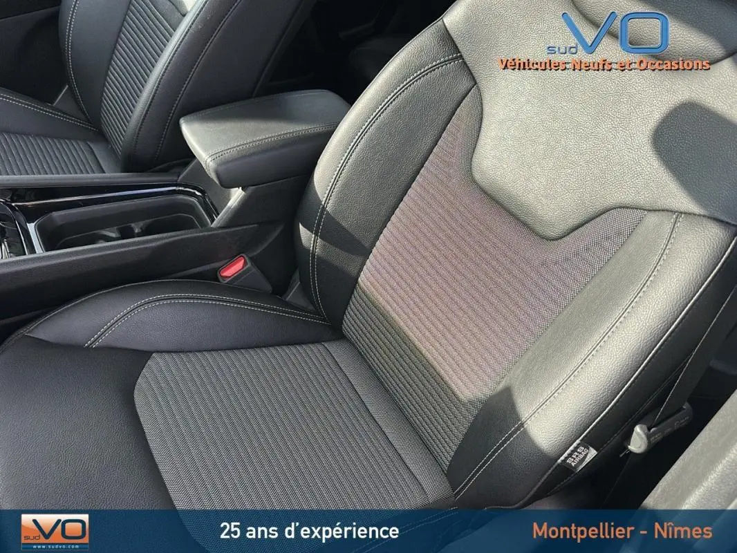 Gros plan sur le siège conducteur en cuir noir et l'accoudoir central du Jeep Compass gris 2024 e-Hybrid Altitude.