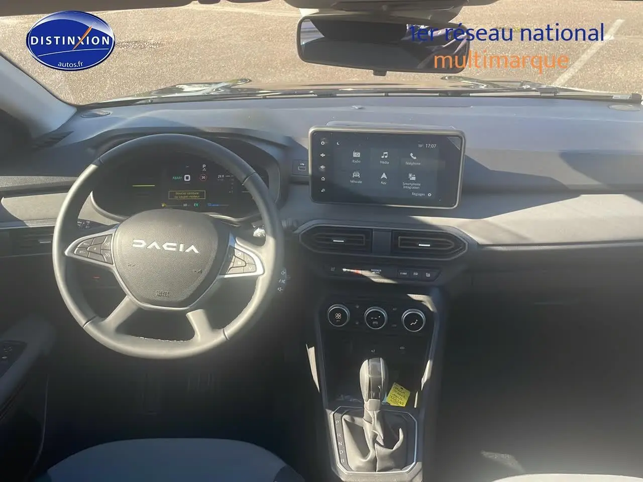 Vue intérieure frontale du tableau de bord du Dacia Jogger noir nacré avec écran tactile et volant multifonction.