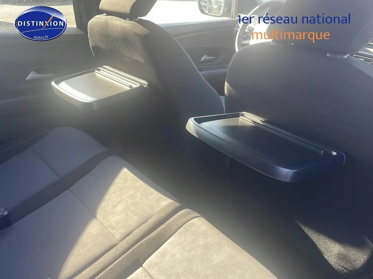 Vue intérieure arrière du Dacia Jogger 2024 avec tablettes rabattables sur les dossiers des sièges avant.