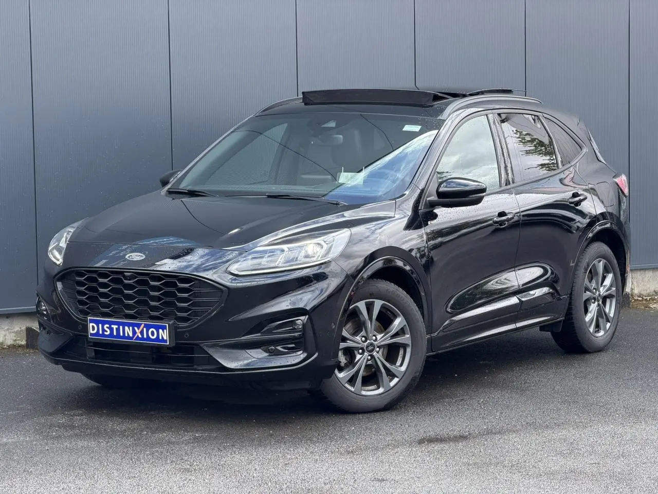 Ford Kuga noir Agathe en vue 3/4 avant droit, avec jantes alliage et toit ouvrant panoramique visible.