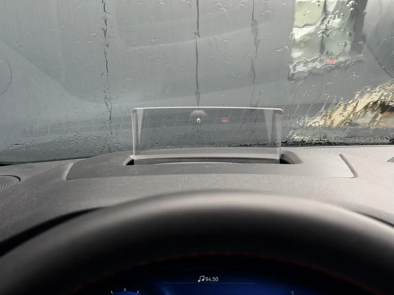 Vue intérieure du tableau de bord du Ford Kuga 2023 avec affichage tête haute et volant partiellement visible.