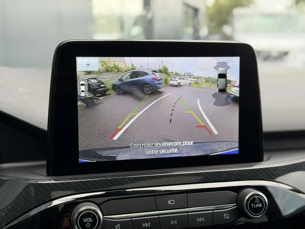 Écran tactile intérieur montrant la caméra de recul du Ford Kuga noir Agathe avec guidage de trajectoire en parking.